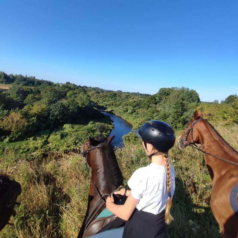 mergina joja žirgu upės pakrante